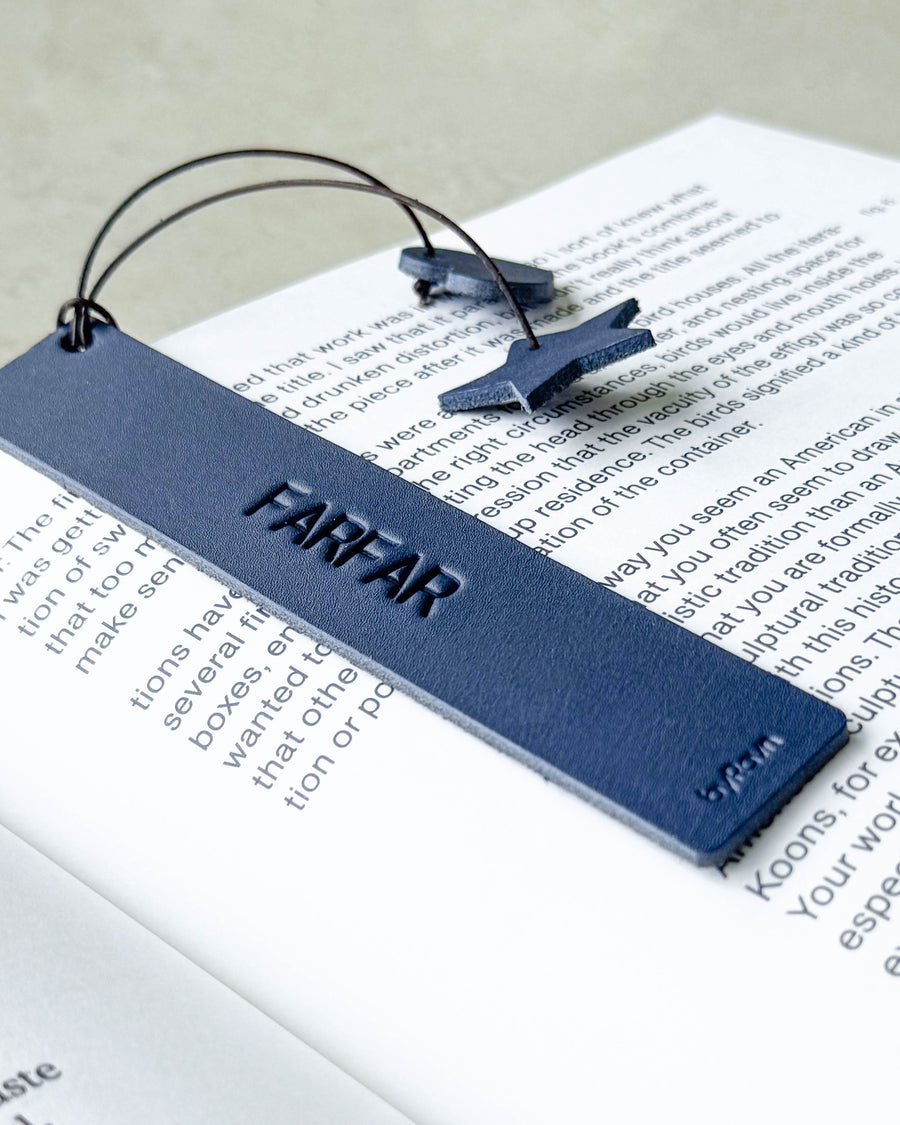 PAGE bokmerke i mørkeblått skinn med graveringen "Farfar" liggende på en oppslått bok med stjerne og hjerte på snor