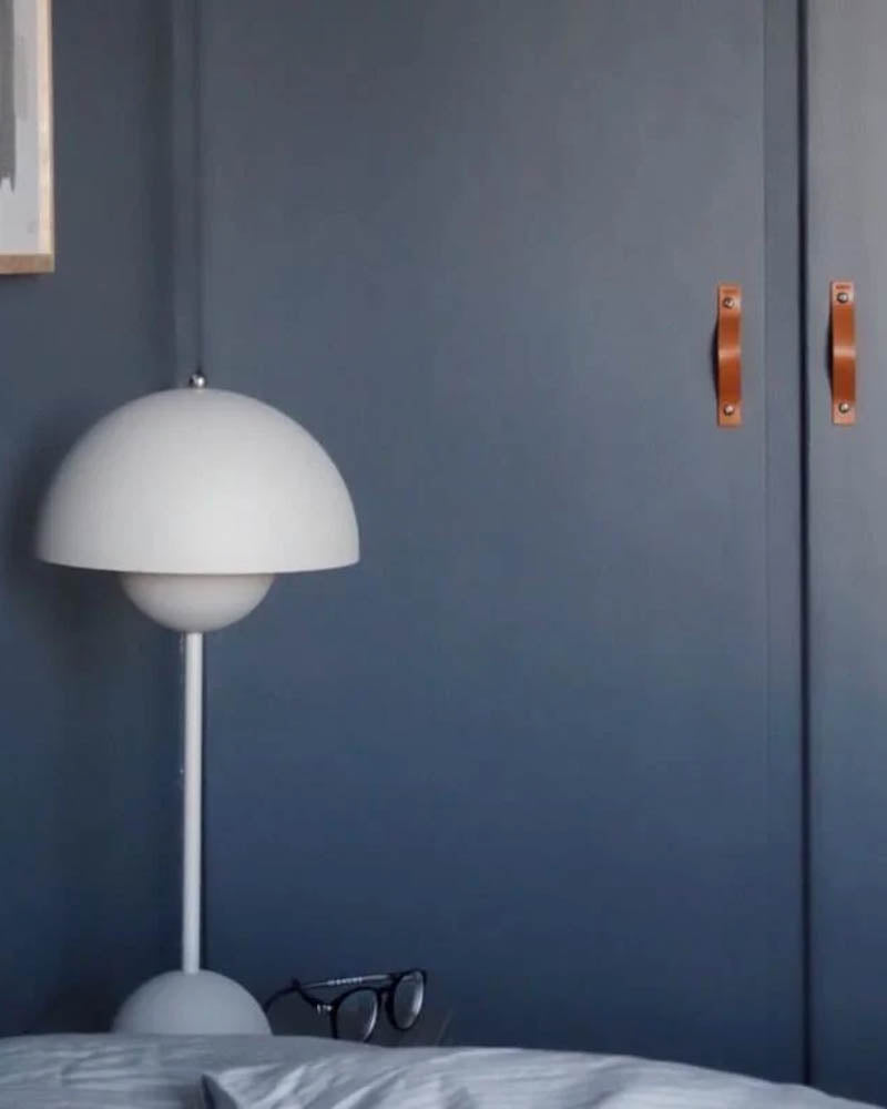 BAND håndtak i cognac skinn på to mørkeblå skapdører på soverom med hvit Flowerpot-lampe
