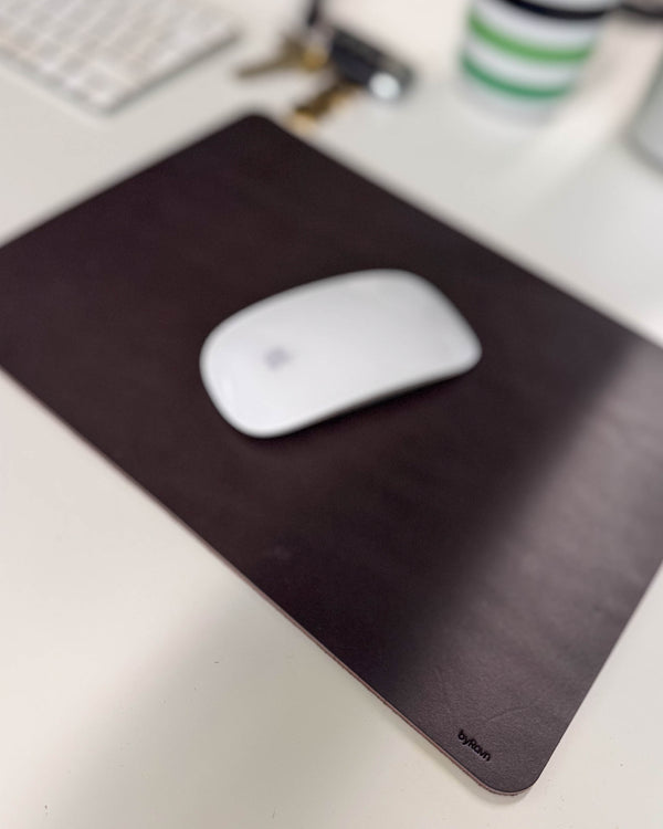 DOS musematte i mørkebrunt skinn med hvit mus på skrivebord med tastatur og nøkler