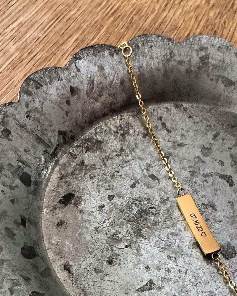 EVI armbånd i gullbelagt stål med datoen "07.10.22" ♡ gravert på avlang plate, liggende på sinkfat