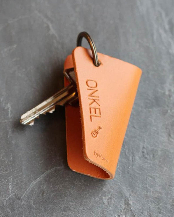 FOLD nøkkelskjuler i cognac skinn med graveringen "Onkel" og liten gitar, med nøkler på mørk skifer
