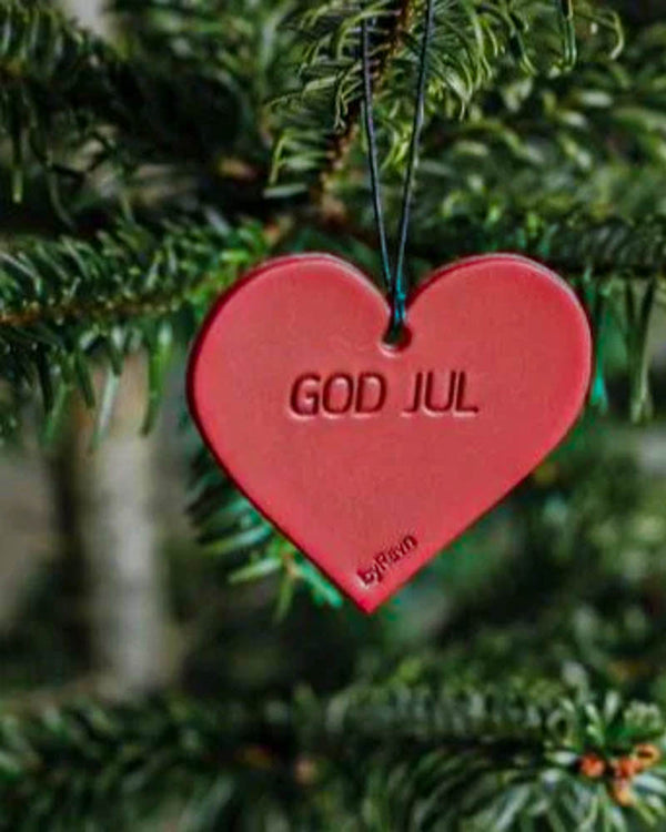 FROST julehjerte i rødt skinn med graveringen "God jul" hengt i grønt juletre