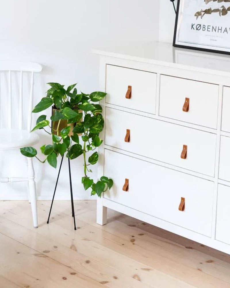 LOOP håndtak i cognac skinn på hvit kommode med seks skuffer i lys stue med plante og København-plakat