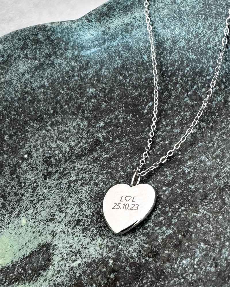 LUV QUOTE halskjede i sølvfarget rustfritt stål med personlig gravering "L ♡ L 25.10.23" på hjerteanheng, på grønn patinert stein