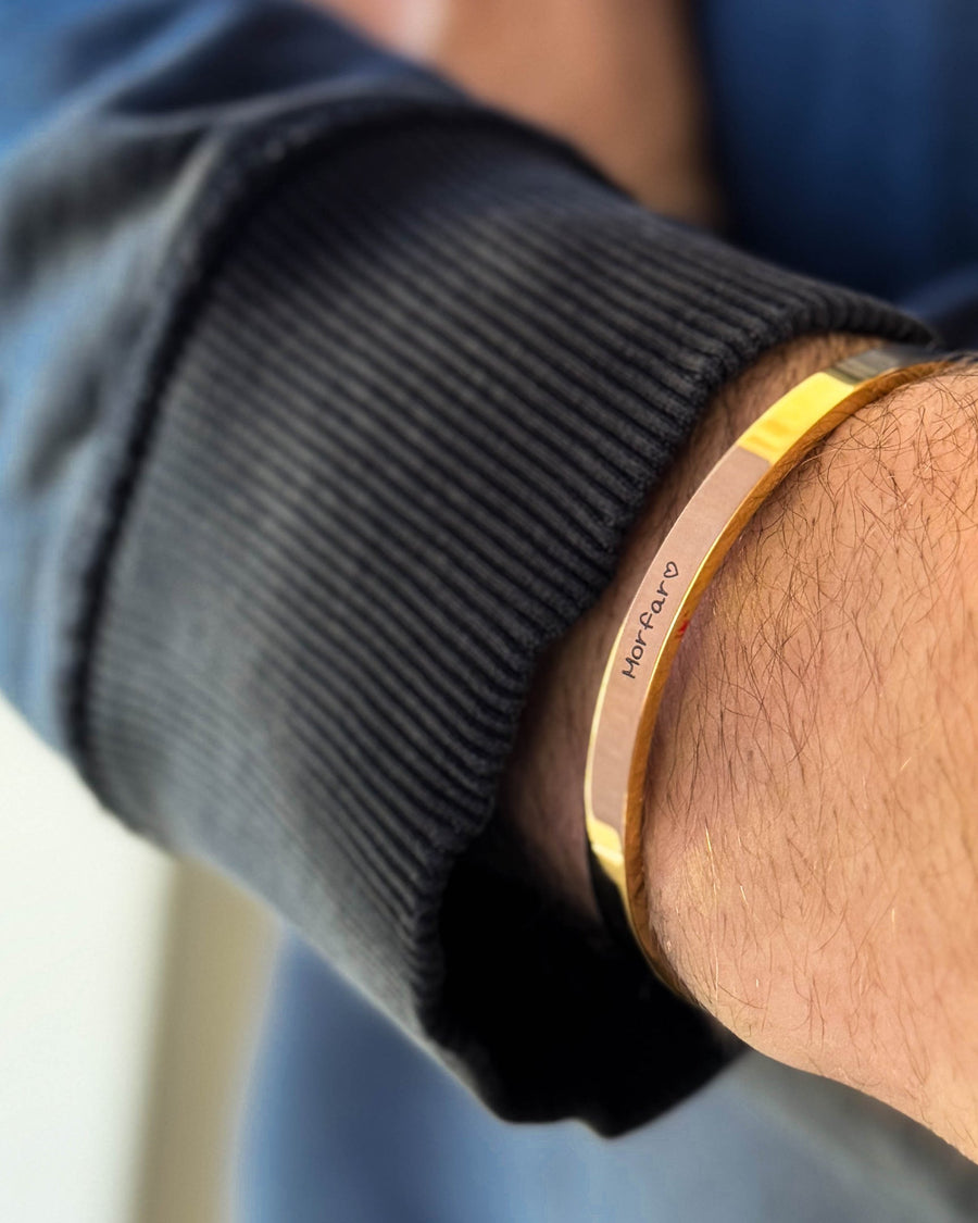 MARS SCRIPT armbånd i gullbelagt stål med "Morfar" ♡ gravert i håndskrift rundt håndleddet, svart sweatshirt