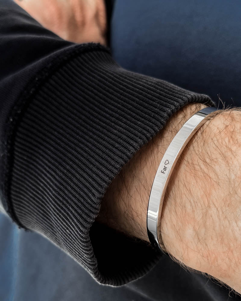 MARS armbånd i sølvfarget rustfritt stål med graveringen "Far" ♡ rundt håndleddet, svart collegegenser