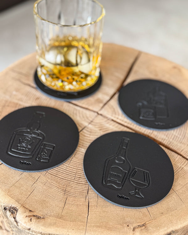 MOKKA brennevin-glassbrikker i svart skinn preget med rom, cognac og gin på treskive ved krystallglass med whisky