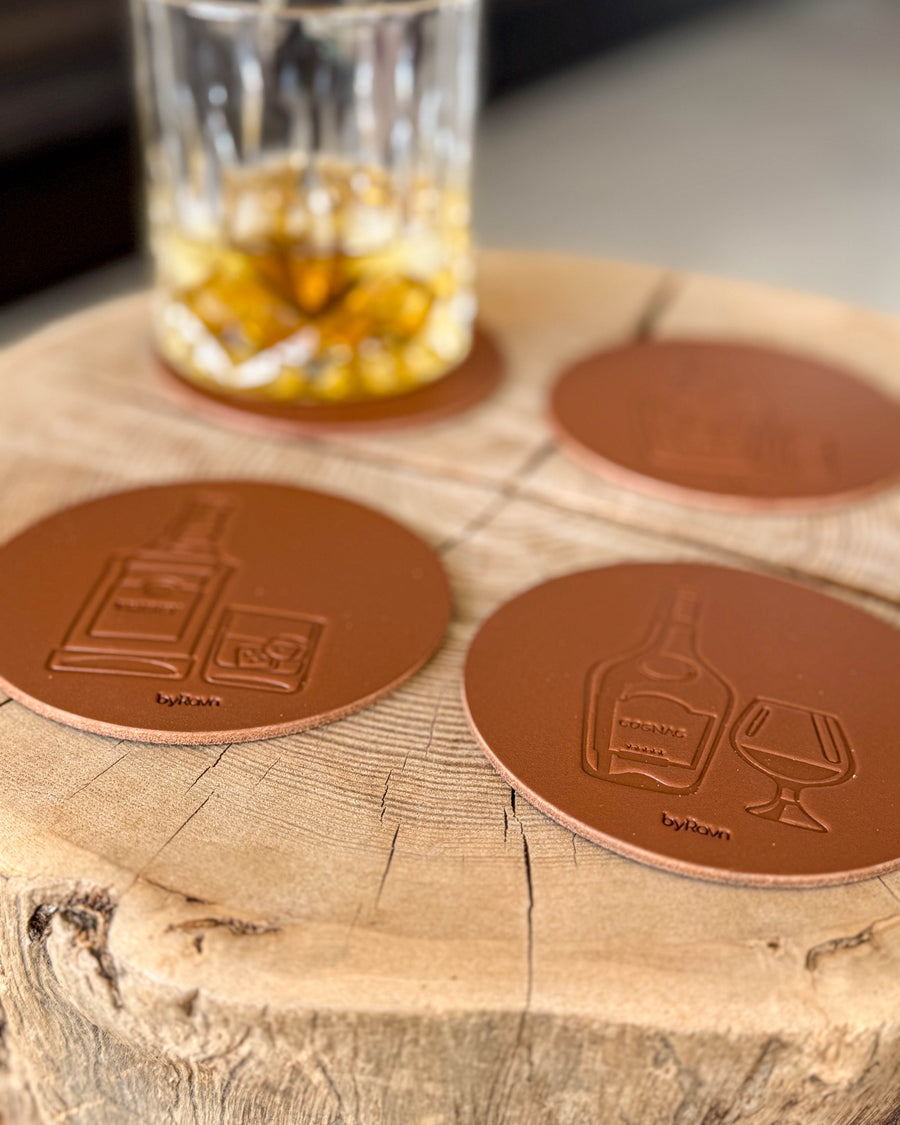 MOKKA brennevin-glassbrikker i cognac skinn preget med whisky og cognac på treskive ved krystallglass med whisky og is