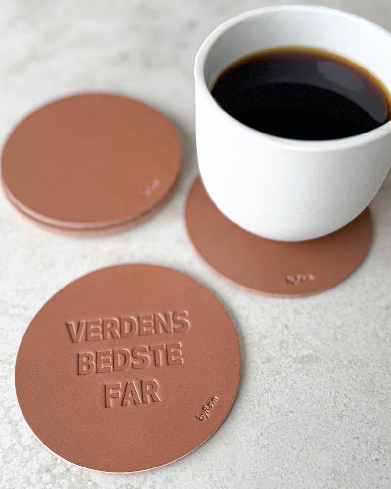 MOKKA glassbrikker i cognac skinn preget "Verdens bedste far" på lyst bord med hvit kaffekopp
