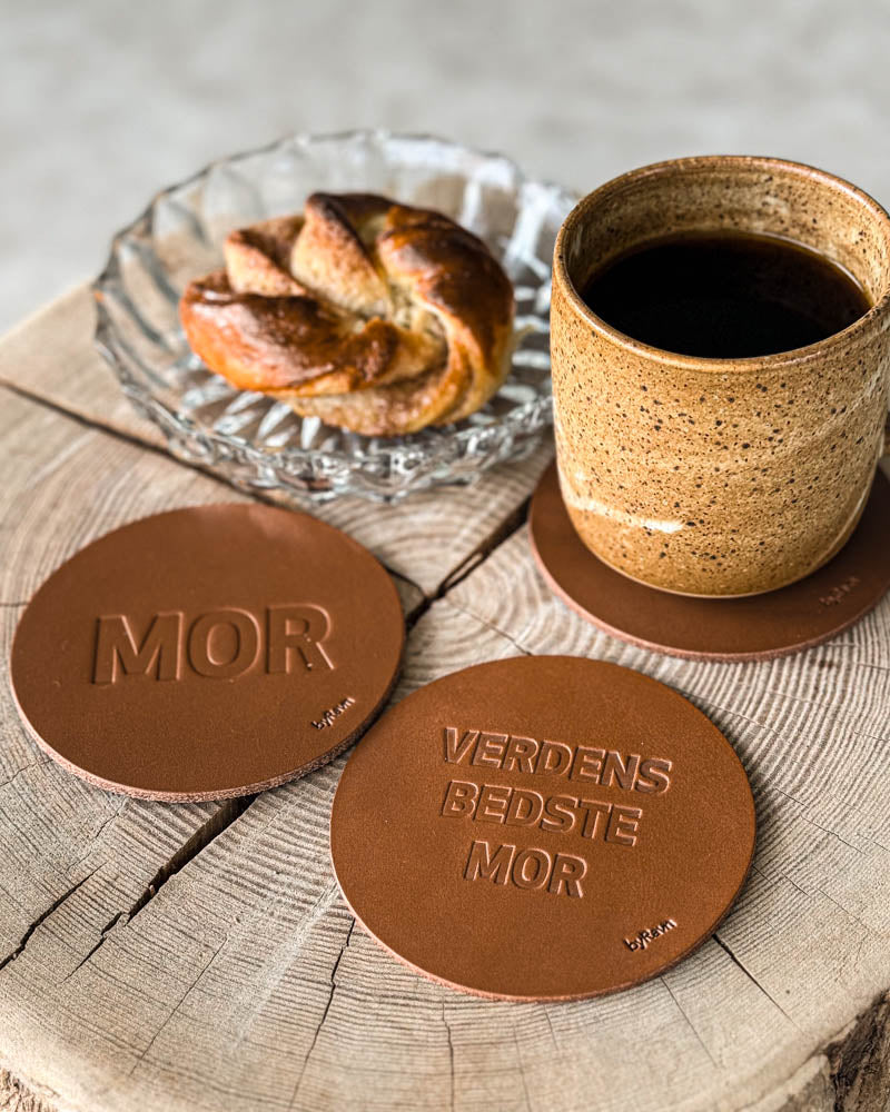 MOKKA glassbrikker i cognac skinn preget "Mor" og "Verdens bedste mor" på treskive med kaffekopp og kanelsnurr