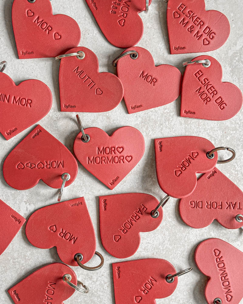 Røde ROSE hjertenøkkelringer i skinn sett ovenfra med graveringer som "Elsker dig ♡ M & M ♡", "Min mor" og "Farmor" ♡