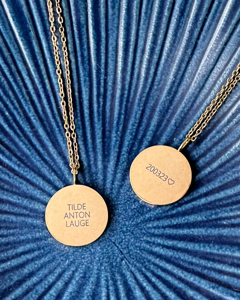 SIA QUOTE navnehalskjede i gullbelagt stål, to anheng gravert "Tilde Anton Lauge" og "200323" ♡, på blå riflet skål