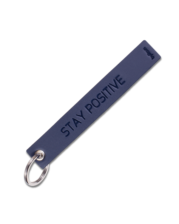 SOLO Large nøkkelring fra byRavn i mørkeblått skinn med graveringen "Stay positive" og nøkkelring i stål