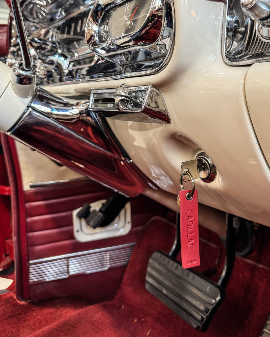 SOLO Small nøkkelring i rødt skinn med graveringen "Cadillac" hengende i tenningen på en veteranbil