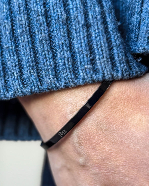 VENUS STICK armbånd i svart stål med gravert fyrstikkfamilie rundt håndleddet, blå ribbestrikk