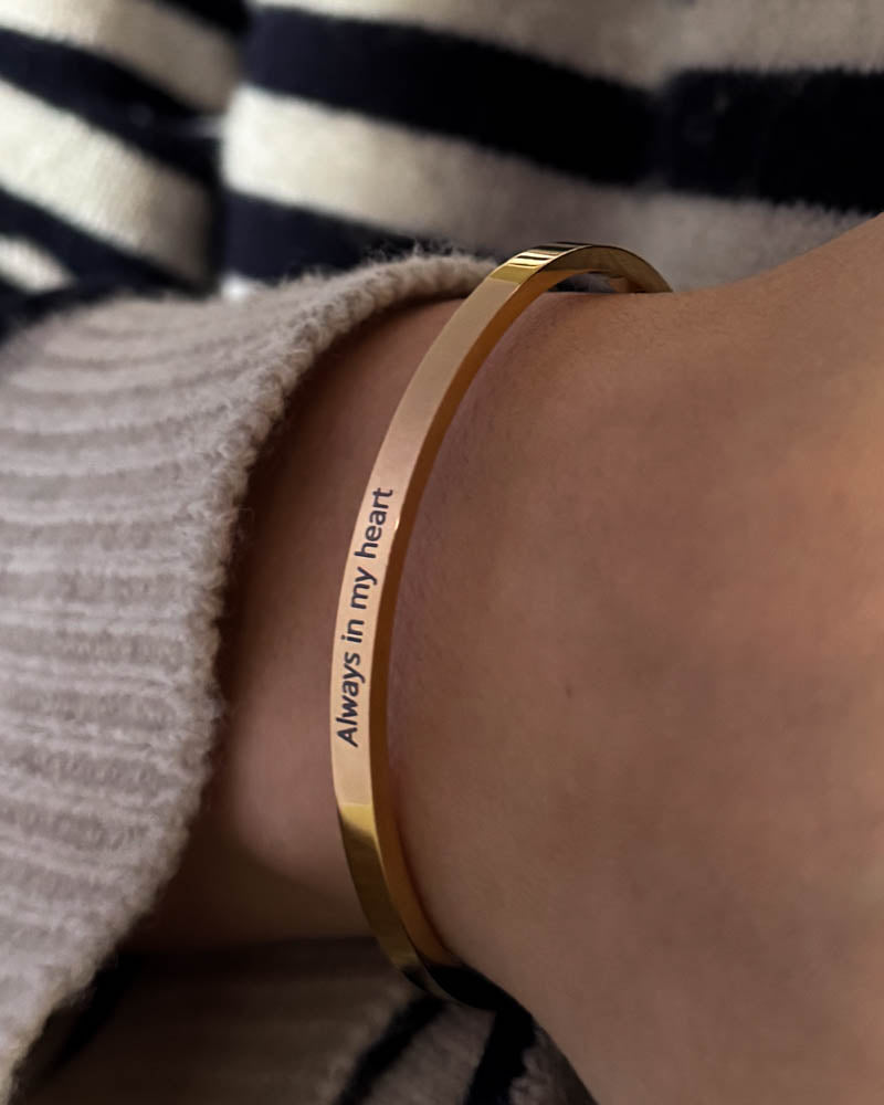VENUS armbånd i gullbelagt stål med graveringen "Always in my heart" rundt håndleddet, stripet bluse